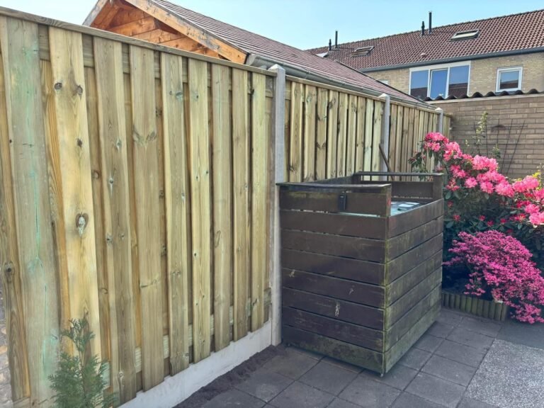Nieuwe schutting met houten containerombouw en bloeiende azalea door Excellent Tuin Onderhoud