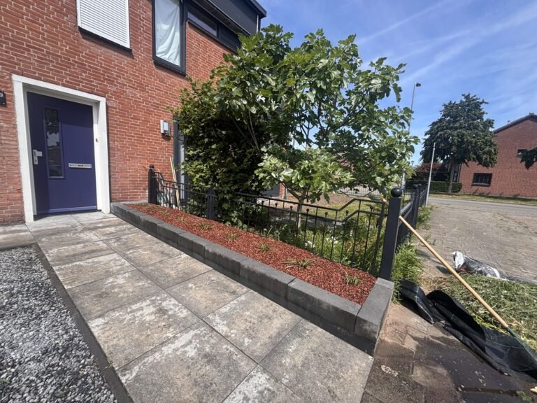 Voortuin met border van boomschors en strakke opsluitband door Excellent Tuin Onderhoud