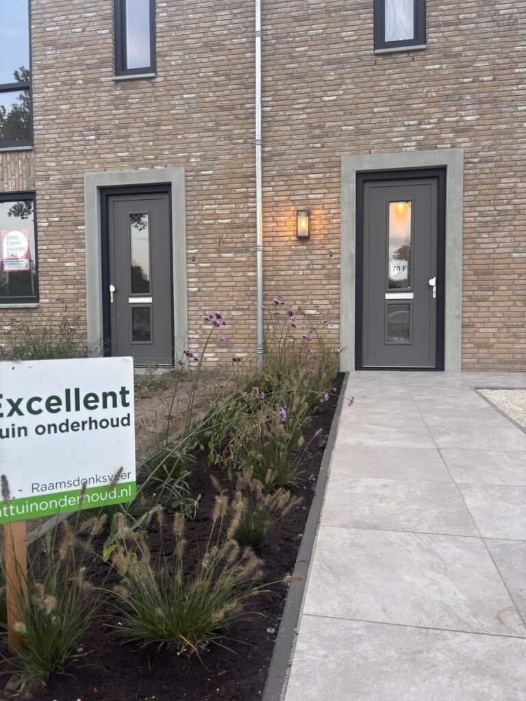 Entree van een nieuwbouwwoning met tegelpad en nieuwe beplanting door Excellent Tuin Onderhoud